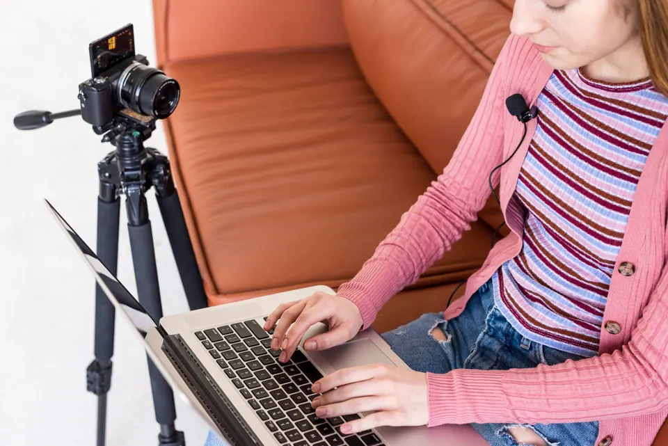 High view blogger sitting couch using her laptop